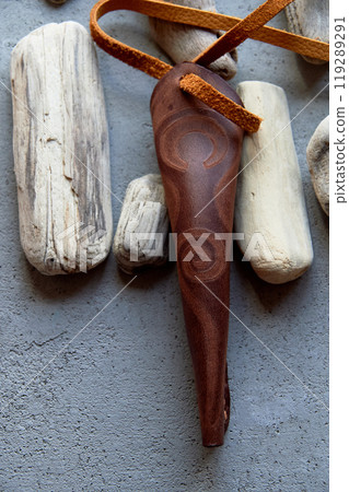 Jew's harp in a brown genuine leather case on a gray background. Sound therapy. 119289291