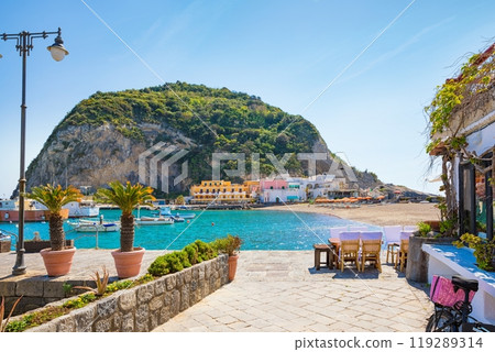 Beautiful coast of village Sant'Angelo, giant green rock in blue sea near Ischia Island, Italy. 119289314