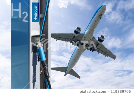 Fuel nozzle with the inscription Hydrogen on a background of airplane and blue sky. Clean mobility concept. Fuel nozzle with the inscription Hydrogen on a background of airplane and blue sky. Clean mobility concept. 119289706