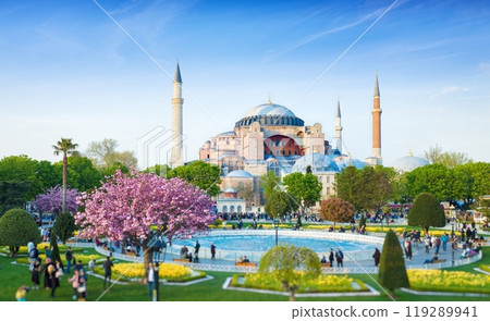 Sultanahmet district in Istanbul, Turkey. Walking people, green grass fields and fountain near famous landmark Hagia Sophia. Bottom of photo is blurred. 119289941