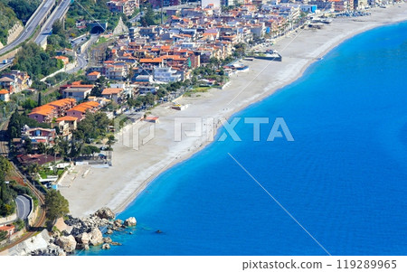 Clear sea, hotels and pebbly beach near Mazzeo Messina on east coast of island of Sicily, Italy. 119289965
