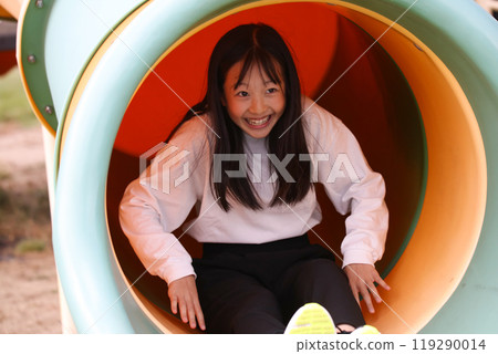 girl playing on the slide girl playing on the slide 119290014