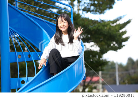 girl playing on the slide 119290015