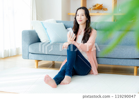 在房間裡操作智能手機的女人 119290047