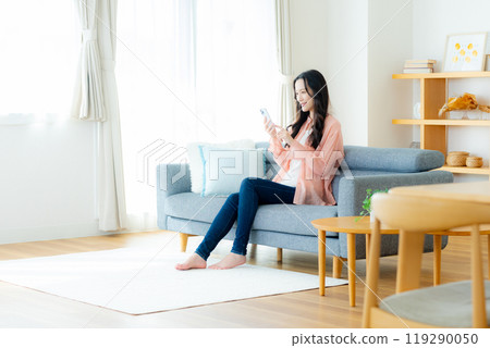 A woman who operates a smartphone in the room 119290050