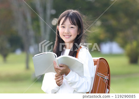 Elementary school student reading a book Elementary school student reading a book 119290085