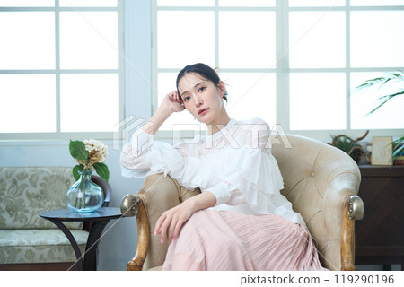 一個女人坐在沙發上 119290196