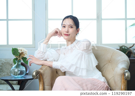 一個女人坐在沙發上 119290197