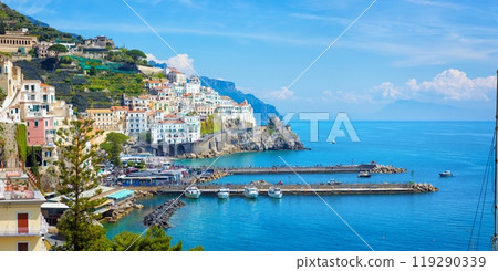 Beautiful Amalfi with hotels on hills leading down to coast, comfortable beaches and azure sea in Campania, Italy. 119290339