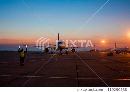 Taxiing passenger airplane on the early morning airport apron Taxiing passenger airplane on the early morning airport apron 119290388