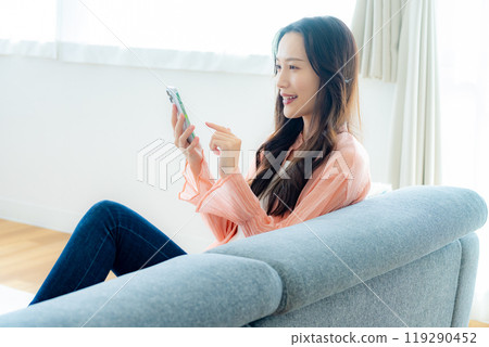 A woman who operates a smartphone in the room 119290452