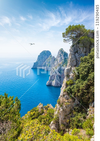 Famous Faraglioni Rocks near Capri Island, Italy. Beautiful paradise image with azure sea in summer sunny day. Famous Faraglioni Rocks near Capri Island, Italy. Beautiful paradise image with azure sea in summer sunny day. 119290485