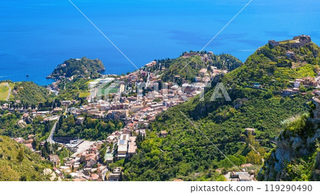 Aerial view of Taormina, on right is Castello Saraceno, in center is Ancient Greek theatre. Taormina located on Sicily island in Italy. Aerial view of Taormina, on right is Castello Saraceno, in center is Ancient Greek theatre. Taormina located on Sicily island in Italy. 119290490