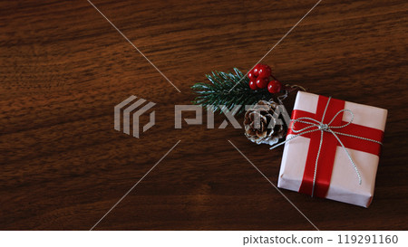 Silver and red ribbon Christmas present gift boxes and pine cones: oak wood grain background Silver and red ribbon Christmas present gift boxes and pine cones: oak wood grain background 119291160