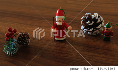 Cute wooden Santa Claus and nutcracker, Christmas ornaments and pine cones Cute wooden Santa Claus and nutcracker, Christmas ornaments and pine cones 119291161
