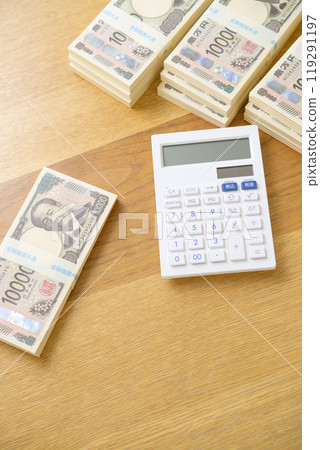 A stack of bills and a calculator on a desk (new bill version) 119291197