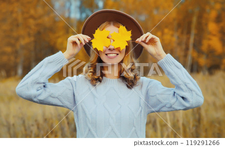 Autumn portrait of happy young woman with yellow leaves, cheerful girl smiling outdoors in park 119291266
