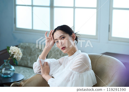 A woman sitting on a sofa A woman sitting on a sofa 119291390