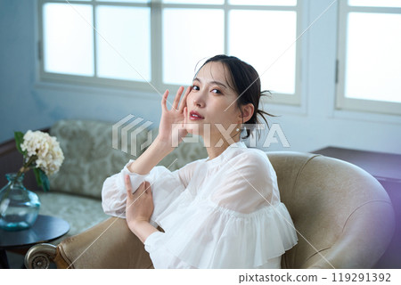 A woman sitting on a sofa A woman sitting on a sofa 119291392