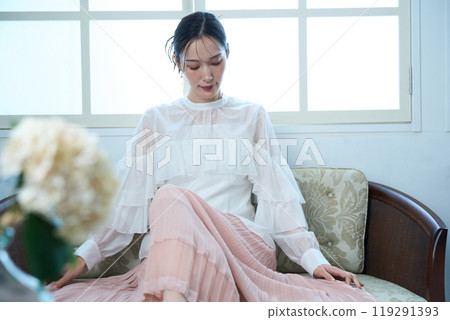 一個女人坐在沙發上 119291393