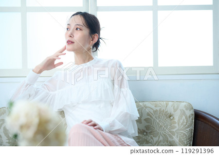 一個女人坐在沙發上 119291396