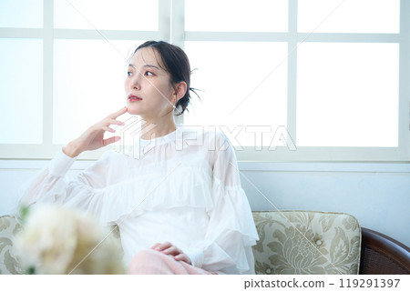 一個女人坐在沙發上 119291397