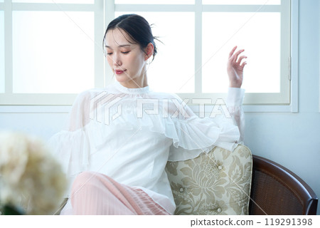 A woman sitting on a sofa A woman sitting on a sofa 119291398