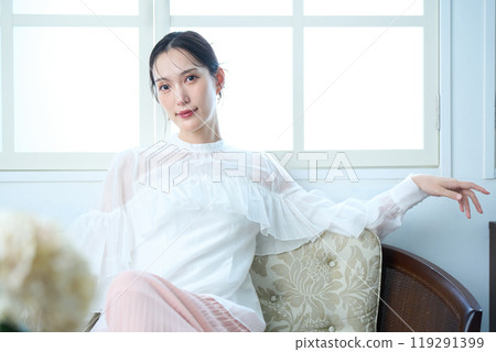 一個女人坐在沙發上 119291399