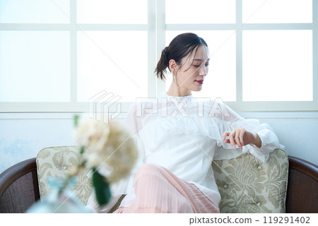 A woman sitting on a sofa A woman sitting on a sofa 119291402