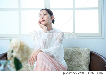 一個女人坐在沙發上 119291407