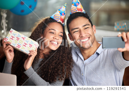 Happy, couple or people take birthday selfie with party hats on for celebrating, relationship and bonding. Smile, man and woman together on special day with gifts for surprise, love and care in home 119291541