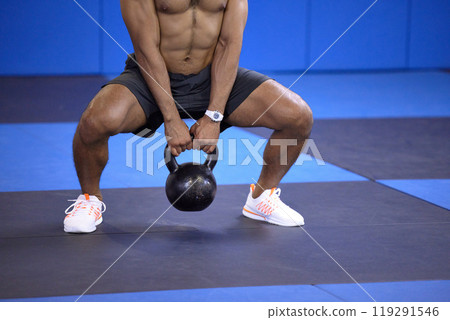 Man, kettlebell and squat in workout at gym, weightlifting and training for power or strong legs. Male person, shirtless and fitness for muscle development, athlete and bodybuilder for exercise 119291546
