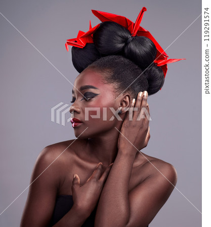 Woman, beauty and origami in studio for cosmetics with red color, Oriental culture and paper bird. African model, bold makeup and grey background for art deco, confidence and creativity with design 119291574
