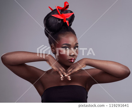 Origami bird, portrait and black woman in studio isolated on gray background with makeup for aesthetic. Glow, creative and cosmetics with pride, beauty and skincare with culture for tradition 119291641