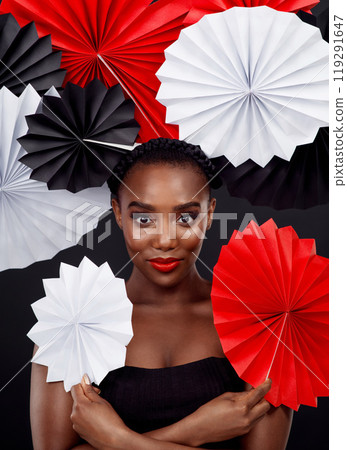 African woman, origami fans and portrait with art deco for creative makeup by dark background. Culture fusion, beauty and female model with oriental craft, traditional and paper on studio backdrop African woman, origami fans and portrait with art deco for creative makeup by dark background. Culture fusion, beauty and female model with oriental craft, traditional and paper on studio backdrop 119291647