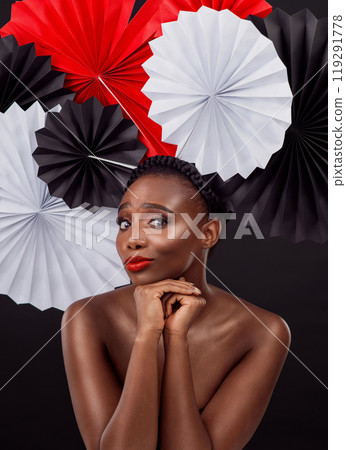 Woman, portrait and beauty with origami fans in studio isolated on a dark background. Face, makeup cosmetics and skincare of black female model with traditional Japanese paper art for geisha hat Woman, portrait and beauty with origami fans in studio isolated on a dark background. Face, makeup cosmetics and skincare of black female model with traditional Japanese paper art for geisha hat 119291778