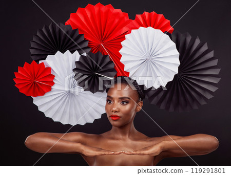 Woman, beauty and hand with origami fans in studio isolated on a dark background. Face, makeup cosmetics and skincare of black female model with traditional craft paper art for cultural geisha hat 119291801