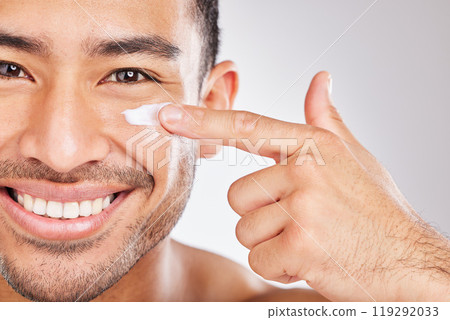 Asian man, portrait or face cream with smile or beauty in studio with antiaging cosmetics, glow and shine. Dermatology, facial product and happy model applying skincare lotion on white background Asian man, portrait or face cream with smile or beauty in studio with antiaging cosmetics, glow and shine. Dermatology, facial product and happy model applying skincare lotion on white background 119292033