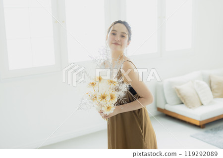 Woman holding a bouquet in the living room 119292089