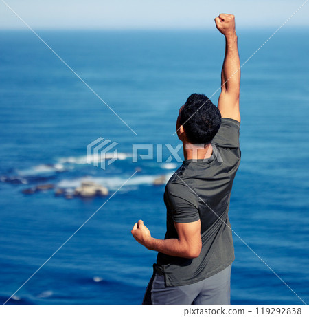 Man, fitness and hiking celebration or hands with fist for exercise victory or outdoor view, back or workout. Male person, trekking and health goals at ocean or explore Australia, journey or travel 119292838
