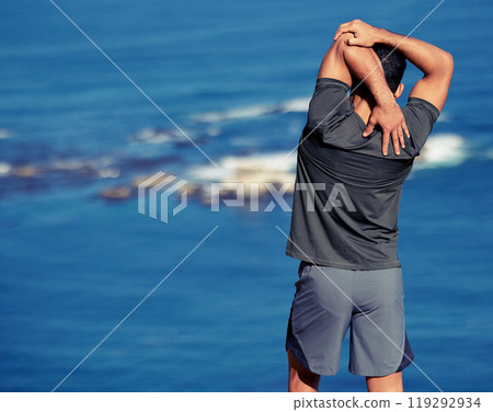 Fitness, arms and man stretching by ocean before workout or morning training routine for race or wellness. Person, back view and outdoor with exercise for warm up for marathon, cardio and health. 119292934
