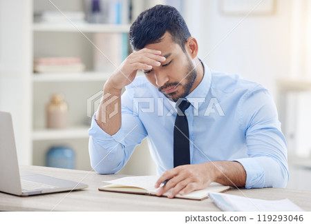 Businessman, desk and write for stress and burnout, notebook and research in office. Headache, corporate and laptop for financial advisor for male person, deadline or notes for audit and overworked 119293046