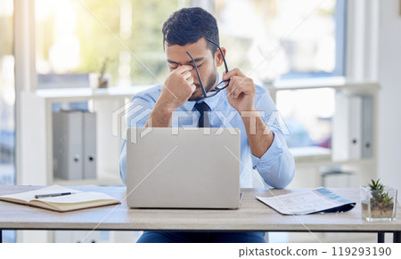 Businessman, desk and laptop for burnout and stress, fatigue and overworked in office. Document, technology and financial advisor and headache for male person, computer and contract for investment 119293190