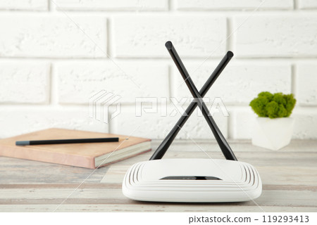 Wireless Wi-Fi router on white background with notebook Wireless Wi-Fi router on white background with notebook 119293413
