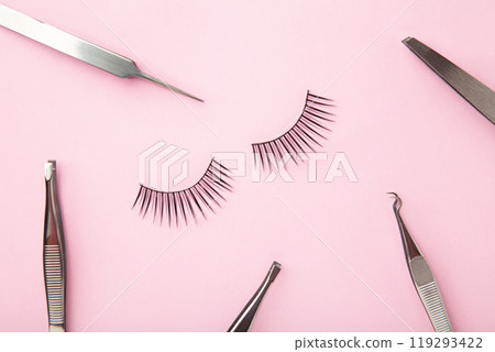 Set of false eyelashes extencions on pink background with tweezers. Minimalism Set of false eyelashes extencions on pink background with tweezers. Minimalism 119293422