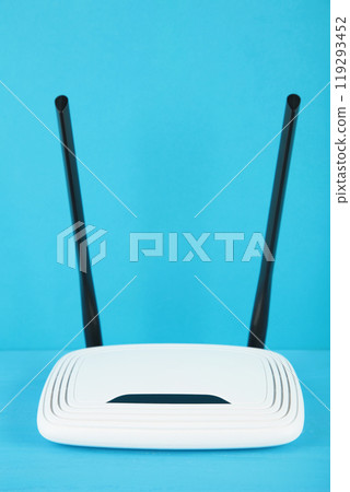 White wi-fi router with black antennas on blue background with copy space. Minimalism. Vertical photo 119293452