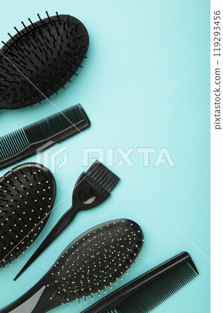 Hair tools, beauty and hairdressing concept - different brushes or combs on blue background. Vertical photo with copy space Hair tools, beauty and hairdressing concept - different brushes or combs on blue background. Vertical photo with copy space 119293456