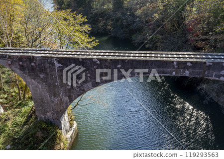 Aerial view of the remains of the Shihoro Line's Third Otofuke River Bridge from Sensui Bridge on a clear autumn day, Kamishihoro Town, Hokkaido 119293563
