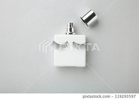 Perfume bottle with eyelashes on grey background Perfume bottle with eyelashes on grey background 119293597