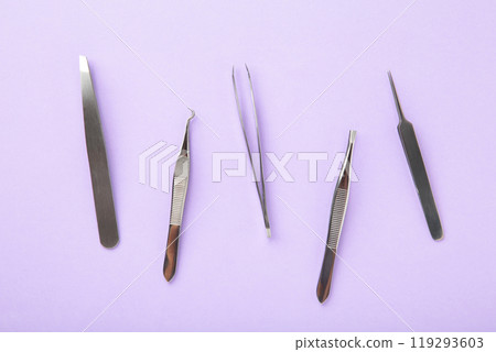 Beauty and fashion concept - tools for Eyelash Extension Procedure. Tweezers on purple background. Copyspace mockup 119293603